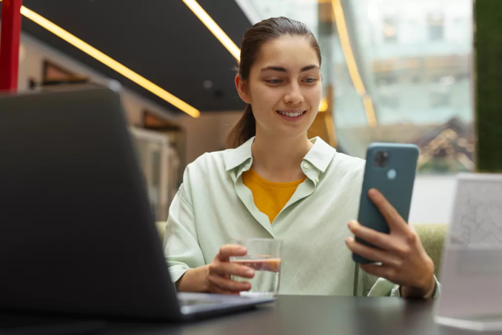 Mulher utiliza celular para ter atendimento on-line por meio de chatbot